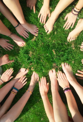 vue de bras où les mains sont assemblées en cercle sur le gazon